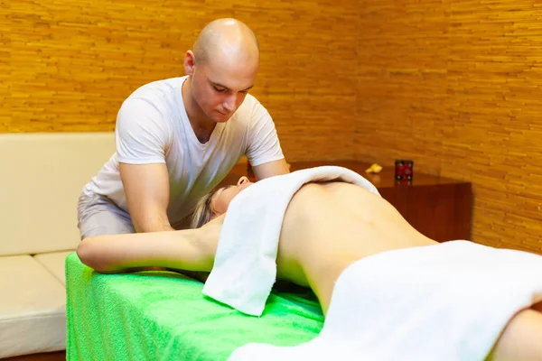 Masseur works on woman arms doing traditional Thai massage on female body in the spa salon. Beauty treatment concept — Stock Photo, Image