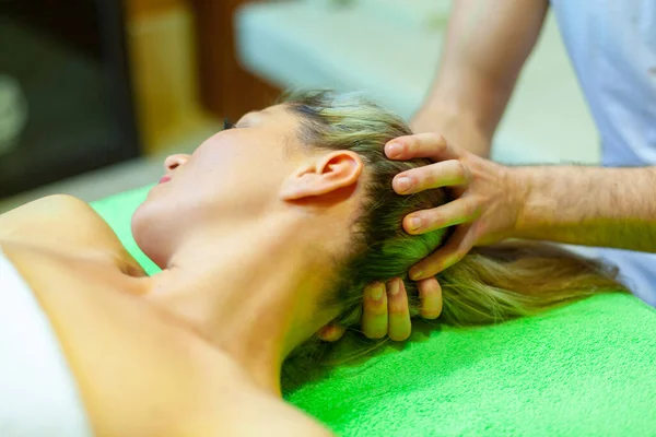 Relaxamento total. Mulher bonita deitada de costas, enquanto massagista profissional massageando a cabeça — Fotografia de Stock