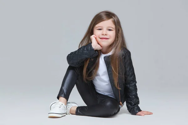 Bebe Fille Aux Cheveux Longs En Veste Et Leggings En Cuir Noir Se Tient Debout En Studio Sur Fond Gris Modele Rocker Stock Photo Bebe Fille Aux Cheveux Longs En Veste Et Leggings En Cuir Noir Se Tient Debout En Studio Sur Fond Gris Modele Rocker Stock Photo
