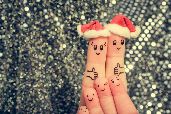 Finger art of large family celebrates Christmas. Concept of group of people laughing in new year hats. Happy couple showing thumbs up. Toned image