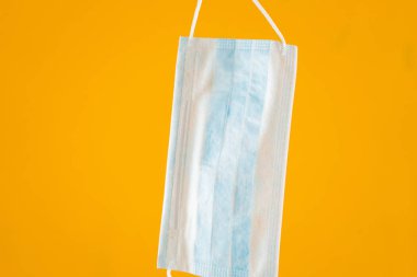 Sarı arka planda tıbbi maske. Koronavirüs. Sağlık Koruma Yöntemleri