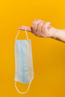 Sarı arka planda tıbbi maske. Koronavirüs. Sağlık Koruma Yöntemleri