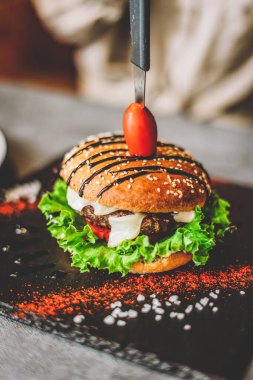 Bıçaklı hamburger. Kötü yemek, fast food..