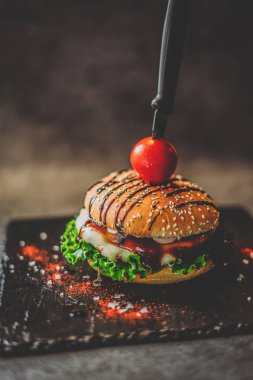 Bıçaklı hamburger. Kötü yemek, fast food..