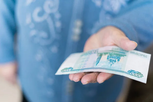 Elderly woman in money in her hands, grandmother holds money