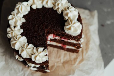 Kremalı ve ahududulu çikolatalı pasta. Parçayı kes