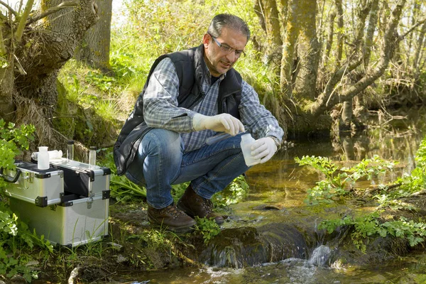 Vue d'un biologiste prélever un échantillon dans une rivière . — Photo