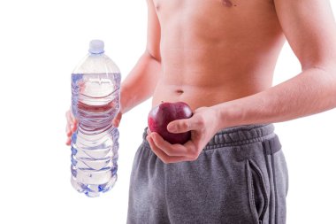Kırmızı elma ve su şişe tutan sportif delikanlı