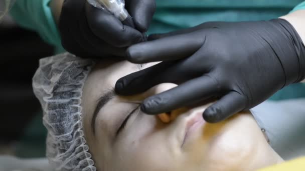 Cosmetologist Applying Permanent Makeup Eyebrow Eyebrow Tattoo Needle Enters Skin — Stock Video