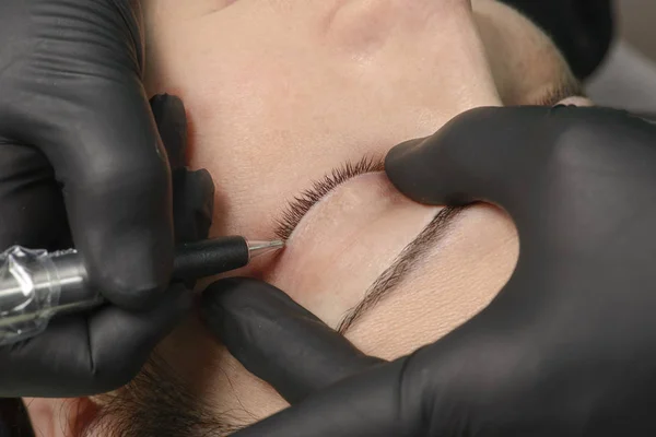 Professional cosmetologist wearing black gloves making permanent — Stock Photo, Image