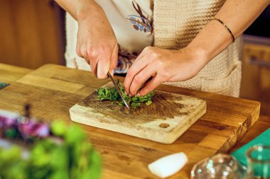 Kadın maydanozu bıçakla doğruyor.