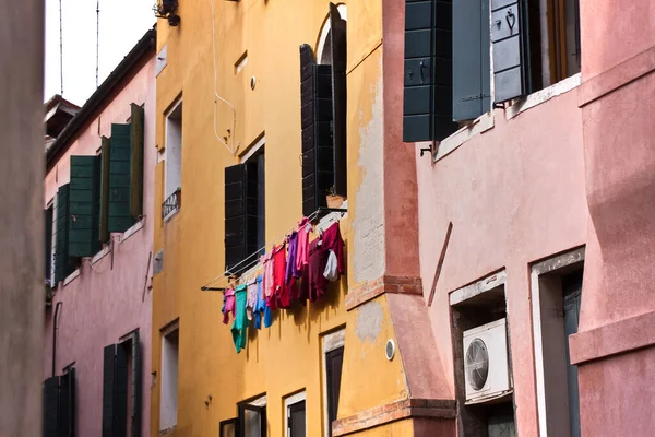 Helder gekleurd linnen op een touw op een achtergrond van een gele muur in de oude stad — Stockfoto