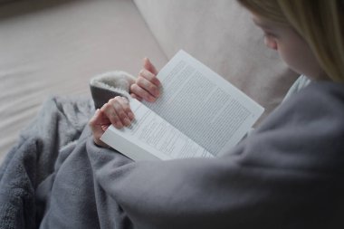 Ekoseli kadın kitap okuyor.