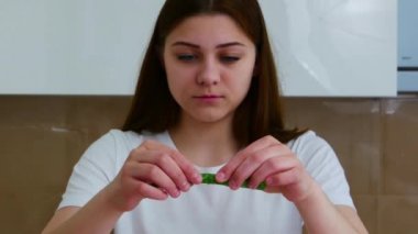 Genç bir kadın evde aloe vera özütüyle sağlıklı yüz maskesi yapıyor.