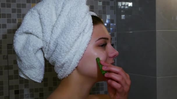 Portrait of Woman looking in the mirror and massaging her face with her fingers — Stock Video