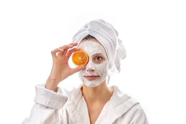 Yüzünde Beyaz Bir Kozmetik Maske Elinde Portakal Dilimleri Olan Güzel — Stok fotoğraf