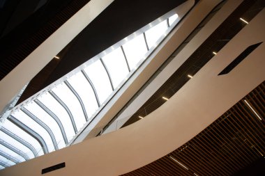 Çok katlı, modern bir ofis binası ya da alışveriş merkezi koyu renk bir ağaç ve hassas bir pencere ile birleştirilmiş..