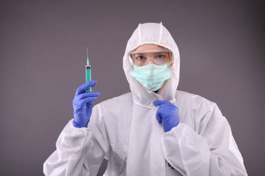 Coronavirus aşısı olan koruyucu kostümlü bir kadın.