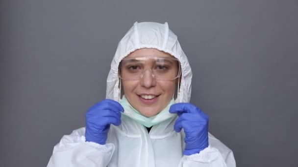 Risque biologique. Femme en costume de protection met un masque et lui convient — Video