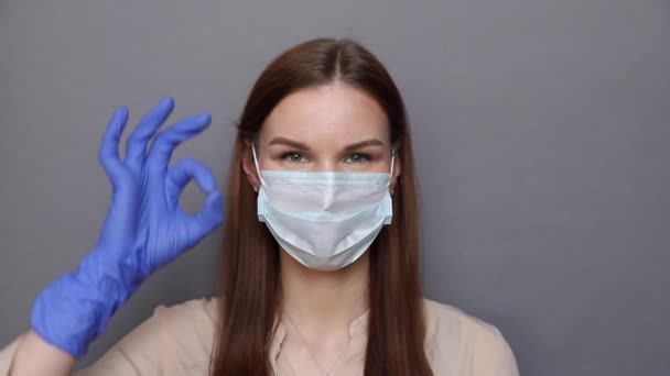 Vrouw in beschermende masker en handschoenen toont ok teken in grappige manier — Stockvideo