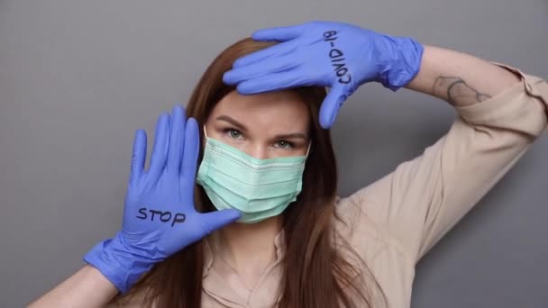 Γυναίκα με προστατευτική μάσκα και γάντια δείχνει "stop COVID-19 — Αρχείο Βίντεο