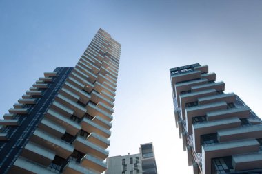 Yakın plan, apartmanların koyu kahverengi fütüristik mimarisinin alt görüntüsü. 01 numara. 20 Milano
