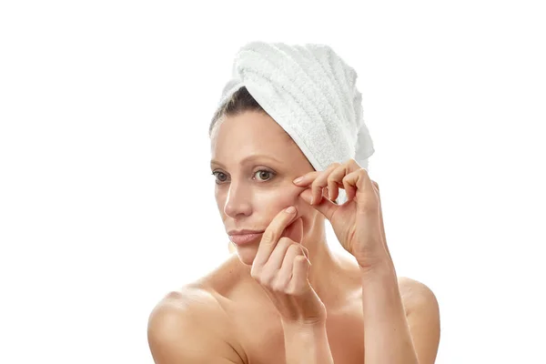 Bella giovane donna con pelle pulita perfetta fa massaggio facciale a casa. Massaggiare la pelle intorno agli occhi. Isolato sfondo bianco . — Foto Stock
