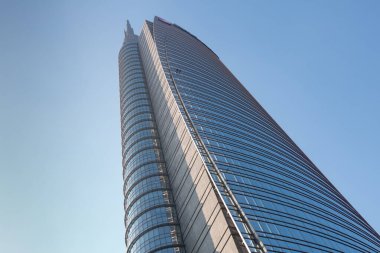 Mavi gökyüzüne karşı çok katlı modern ofis binasının tepesinde. 01.2020 Milano