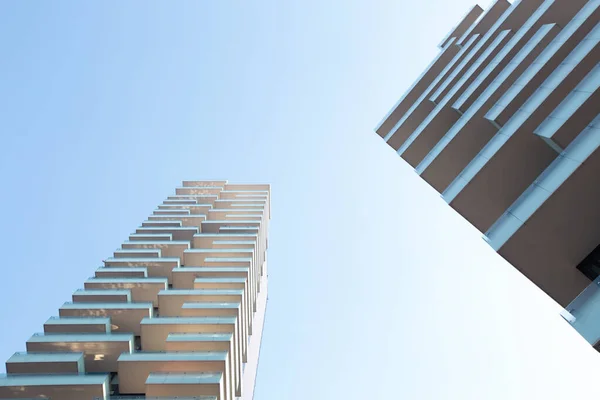 Bâtiments de formes géométriques différentes avec de grands balcons harmonieusement harmoniser les uns avec les autres en blanc contre un ciel bleu. 01.2020 Milan — Photo