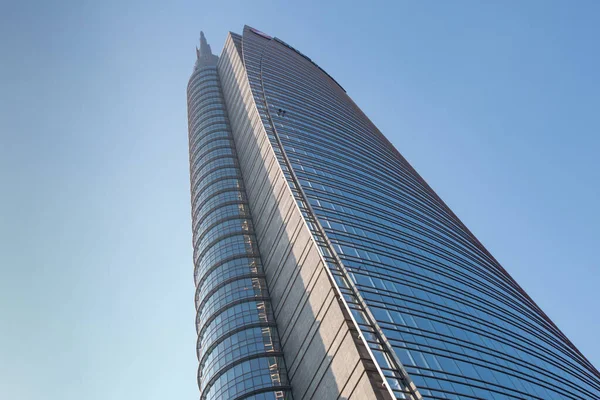 Le sommet d'un immense immeuble de bureaux moderne à plusieurs étages contre un ciel bleu. 01.2020 Milan — Photo