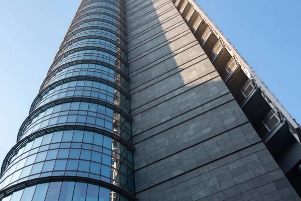 青い空に対する巨大な多階建ての近代的なオフィスビルのクローズアップ。01.2020ミラノ. — ストック写真