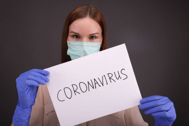 Kadın doktor Coronavirus 'u durdurmak için bir işaret tutuyor.