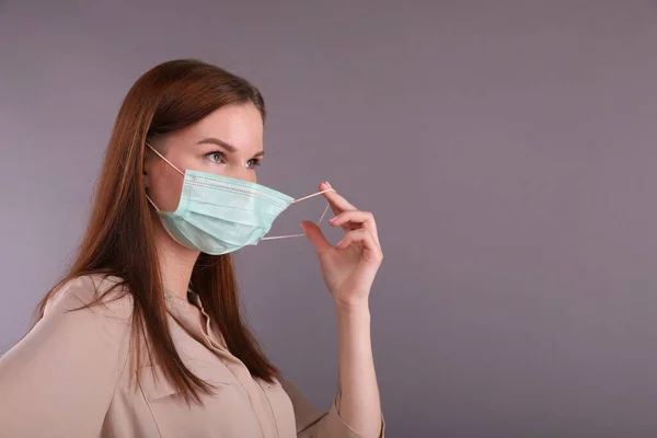 看護師は、コロナウイルスを保護するための外科用マスクを置きます — ストック写真