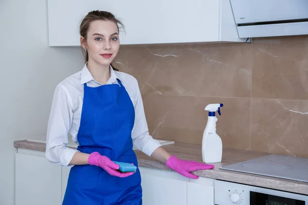 Mulher bonita limpando sua cozinha apartamento. Limpeza com detergente . — Fotografia de Stock