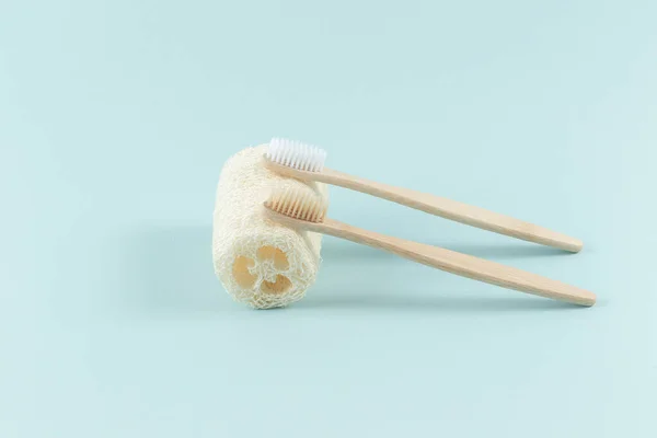 Dos cepillos de dientes se encuentran en un loofah ambiental natural, diseñado para el cuerpo, sobre un fondo blanco — Foto de Stock