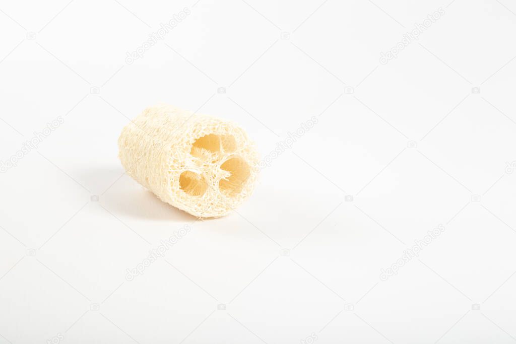 Natural environmental loofah lies on a white background core turned towards us.