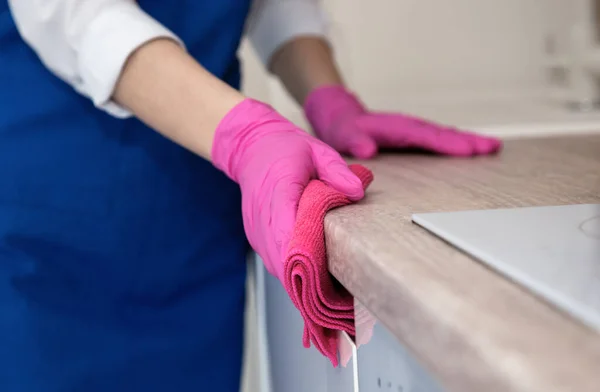 ピンクのゴム手袋の女の子がアパートのキッチンを洗う. — ストック写真