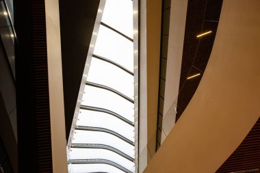 Modern bir ofis binasında devasa bir tavan, cam parmaklıkların arkasına cam yerleştirilmiş bir alışveriş merkezi. 01.2020 Milano.