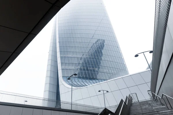 青い窓のある巨大なオフィスビルにつながる階段。01.2020ミラノ. — ストック写真