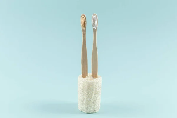 Dos cepillos de dientes respetuosos con el medio ambiente están en envases ecológicos. Cero residuos. Sobre un fondo azul . — Foto de Stock