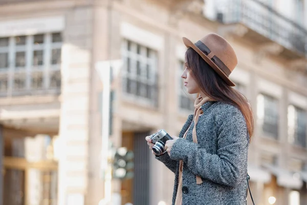 Красивая брюнетка-туристка держит в руках фотоаппарат . — стоковое фото