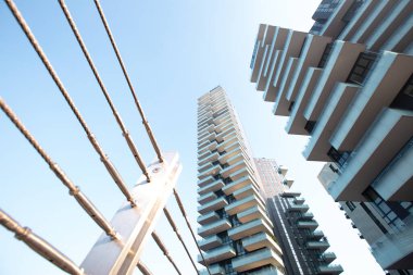 Köprünün demir parmaklıkları mavi gökyüzüne karşı güzel beyaz evlerle uyum içinde. 01.2020 Milano