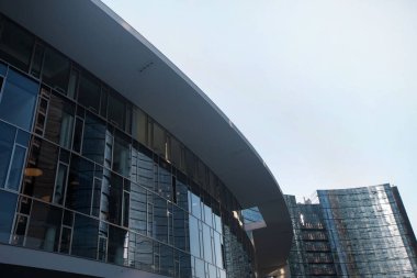 Binanın her tarafında mavi gökyüzüne bakan pencereleri olan modern yarı dairesel bir bina. 01.2020 Milano