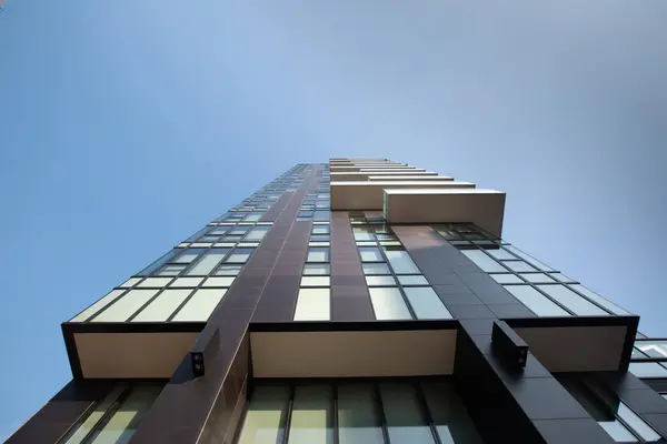 Close-up, bottom view of a dark brown futuristic architecture of an apartment building against a blue sky. 01.2020 Milan. — Stock Photo, Image