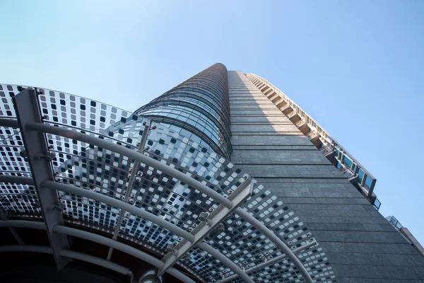 Immeuble de bureaux haut de plusieurs étages gris avec un motif géométrique bleu et bleu contre un ciel bleu. 01.2020 Milan — Photo