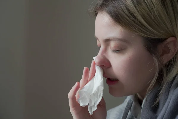 Sick woman with runny nose sitting under the blanket. — Stock Photo, Image