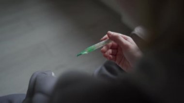 Battaniyeye sarılı bir kız ateşini ölçüyor. Orvi, koronovirüs, grip, akut solunum hastalığı belirtileri..