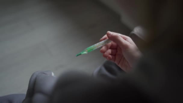 Een meisje gewikkeld in een deken controleert haar temperatuur. Temperatuur van Orvi, coronovirus, griep, acute ademhalingsziekte. — Stockvideo