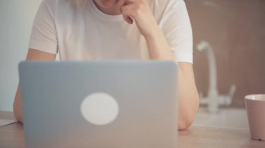 Parlak bir odada dizüstü bilgisayarla çalışan genç bir kız..