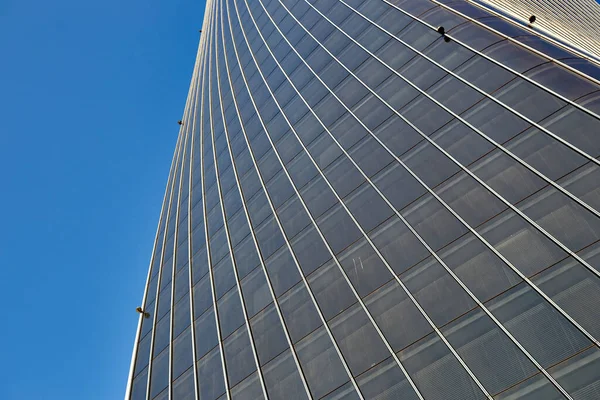 Vue du bas d'un grand immeuble de bureaux avec d'énormes fenêtres contre un ciel bleu . — Photo